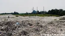 A landfill in front of smokestacks
