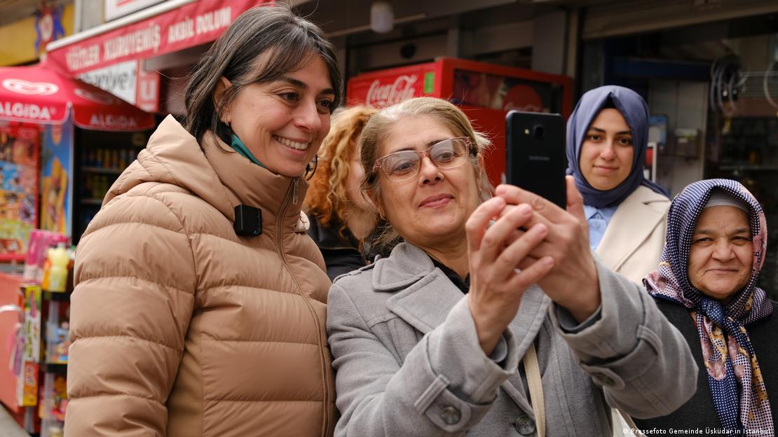 Üsküdar Belediye Başkanı Sinem Dedetaş, sokakta Üsküdarlı bir vatandaşla fotoğraf çektiriyor