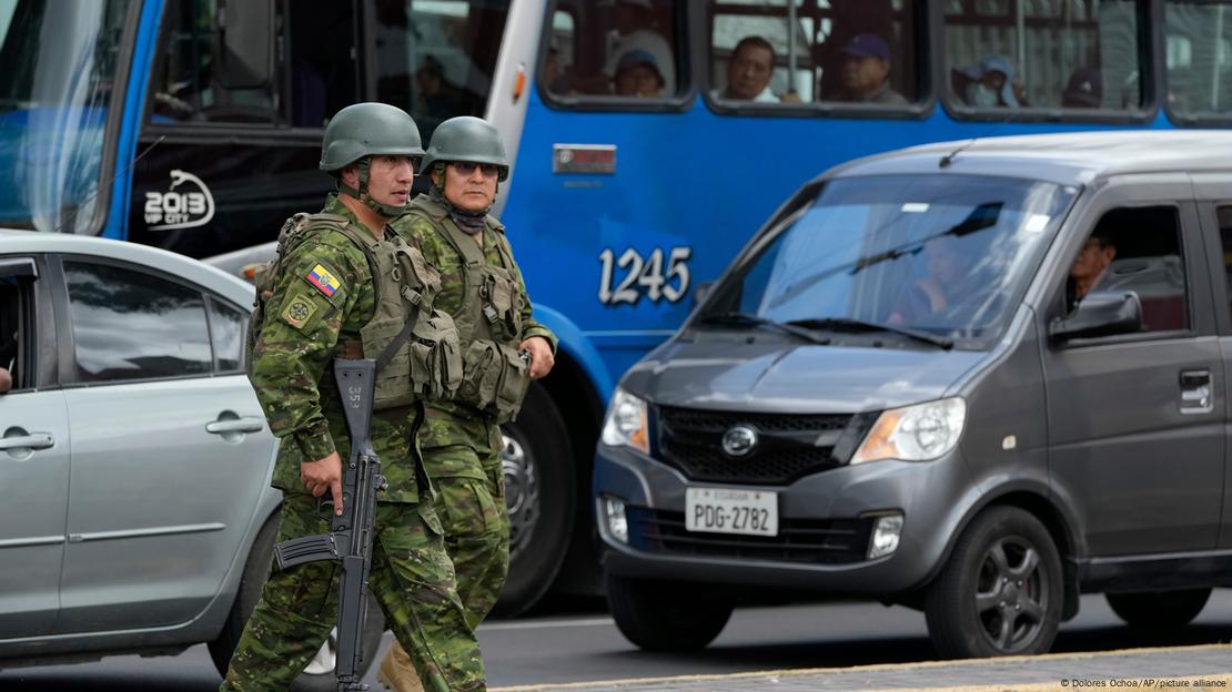 Dos miembros de las Fuerzas Armadas, con sus armas en mano, en las calles de Quito.
