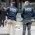 Agentes de la Policía de Nueva York frente a la corte de Justicia, donde todavía se ven en el suelo cenizas humeantes y varios extintores.