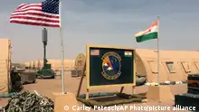 16/04/2018**ARCHIVBILD**FILE - In this photo taken Monday, April 16, 2018, a U.S. and Niger flag are raised side by side at the base camp for air forces and other personnel supporting the construction of Niger Air Base 201 in Agadez, Niger. The U.S. says it has about 5,200 Africa Command personnel, troops and others, on the continent, plus about 800 other Department of Defense personnel. (AP Photo/Carley Petesch, File)
