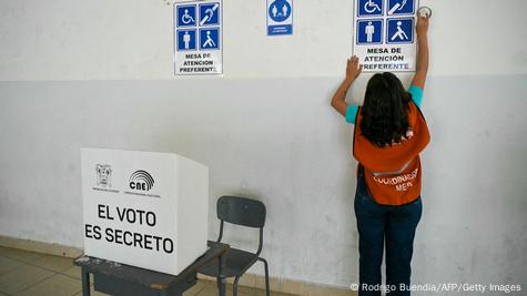 Una coordinadora de una mesa de voto prepara la sala para el referendo.