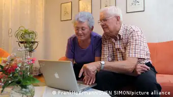 An elderly couple using digital media