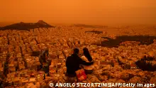 23/04/2024 **TOPSHOT - A couple sits on Tourkovounia hill, as southerly winds carry waves of Saharan dust, in Athens, on April 23, 2024. Clouds of dust blown in from the Sahara covered Athens and other Greek cities on April 23, 2024, one of the worst such episodes to hit the country since 2018, officials said. The yellow-orange haze smothered several regions, limiting visibility and prompting warnings of breathing risks from the authorities. (Photo by Angelos TZORTZINIS / AFP) (Photo by ANGELOS TZORTZINIS/AFP via Getty Images)