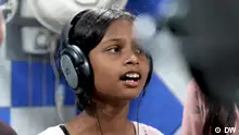 Ein indisches Mädchen mit Kopfhörern singt. Die Rechte sind nur für diesen Beitrag gegeben. Zu verwenden ausschließlich im Magazin Global Us vom 29.04.2024.