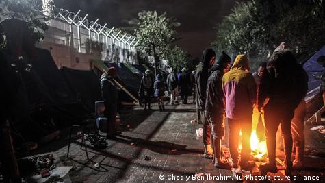 Migrants se réchauffant la nuit autour d'un feu, en Tunisie (archive de 2023)