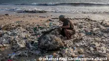 BALI, INDONESIA - MARCH 19: A man collects plastic trash to be recycled at polluted shore during monsoon season in Kedonganan Beach, Badung, Bali, Indonesia on March 19, 2024. During the rainy season, large amount of plastic trash and debris tend to wash up on shorelines, due to illegal dumping in rivers and coastal areas, thereby worsening marine pollution. Indonesia is one of the world's largest contributors to marine plastic pollution. Johannes Panji Christo / Anadolu