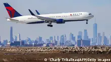 A Boeing 767 passenger aircraft of Delta airlines arrives from Dublin at JFK International Airport in New York as the Manhattan skyline looms in the background on February 7, 2024. (Photo by Charly TRIBALLEAU / AFP) (Photo by CHARLY TRIBALLEAU/AFP via Getty Images)