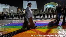 Supporters of Shiite Muslim leader Moqtada Sadr step on a LGBTQ rainbow flag, during a demonstration in Sadr City, in response to the burning of Quran in Sweden, Baghdad, Iraq, Wednesday, July 12, 2023. (AP Photo/Hadi Mizban)