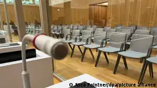 Ein Mikrofon ist an einem Tisch in dem Gerichtssaal im Oberlandesgericht angebracht, in dem der Reichsbürger-Prozess verhandelt wird. Die Angeklagten werden hinter Trennwänden aus Glas an Plätzen mit Mikrofonen sitzen. +++ dpa-Bildfunk +++