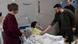 Ein Mann (Wolodymyr Selenskyj) gibt einem Jungen im Krankenbett (Illja Matwijenko) die Hand Ein Mann (Wolodymyr Selenskyj) gibt einem Jungen im Krankenbett (Illja Matwijenko) die Hand