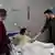 Zelenski aperta mão de Illya, que está recostado em uma cama de hospital