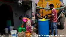 Residents of Ambedkar Nagar, a low-income settlement in the shadows of global software companies in Whitefield neighborhood, collect potable water from a private tanker in Bengaluru, India, Monday, March 11, 2024. Water levels are running desperately low, particularly in poorer regions, resulting in sky-high costs for water and a quickly dwindling supply. (AP Photo/Aijaz Rahi)
