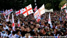 Regierungsfreundliche Demonstranten mit georgischen Nationalflaggen nehmen an einer Kundgebung zur Unterstützung des russischen Gesetzes in Tiflis, Georgien, teil. Dieses Gesetz sieht vor, dass Medien und nicht-kommerzielle Organisationen als unter ausländischem Einfluss stehend registriert werden müssen, wenn sie mehr als 20 % ihrer Mittel aus dem Ausland erhalten. +++ dpa-Bildfunk +++
