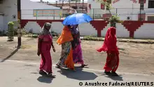 FILE PHOTO 26.04.2024: Women shelter under an umbrella due to the heat as they leave a polling station after casting their vote, during the second phase of the general election in Mathura, in the northern Indian state of Uttar Pradesh, India, April 26, 2024. REUTERS/Anushree Fadnavis/File Photo