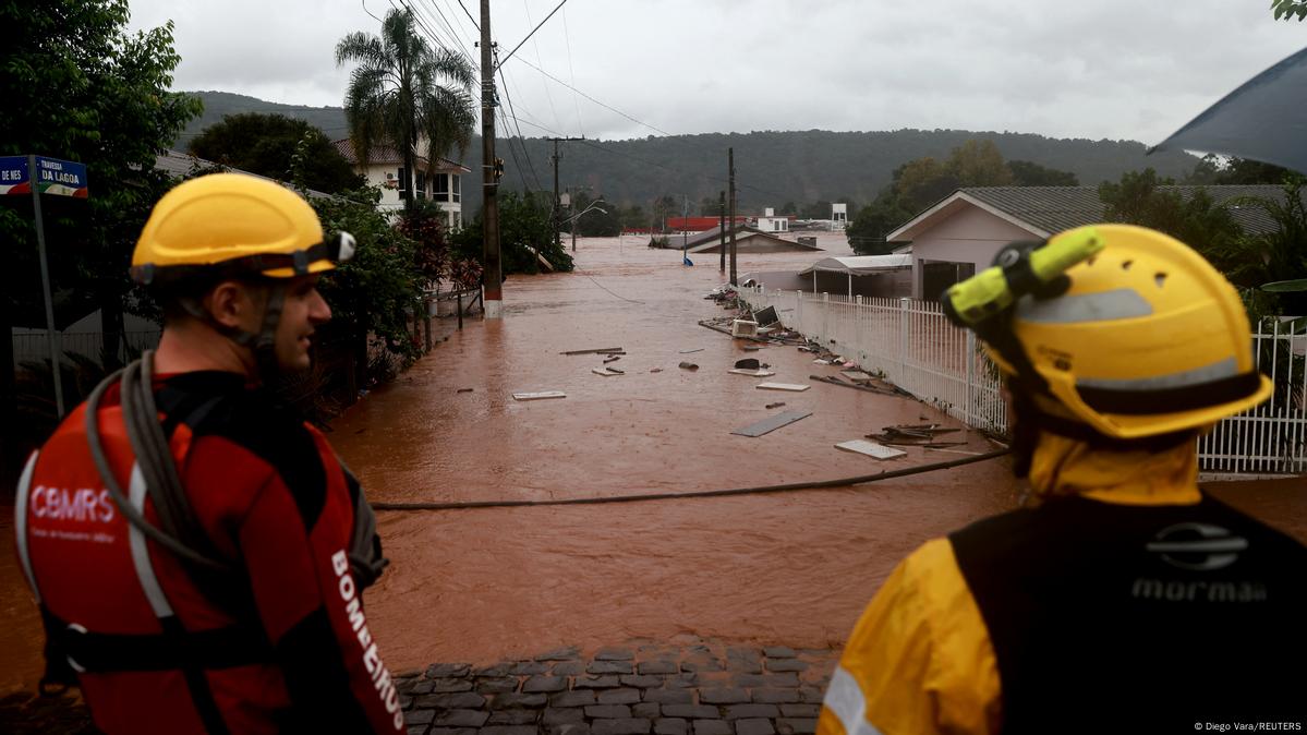 Dos rescatistas delante de una calle inundada.