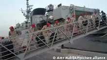 Saudi soldiers carry luggage of Yemeni evacuees as they disembark the Saudi HMS Abha ship, traveling rom Port Sudan, after docking at Jeddah port, Saudi Arabia, Sunday, May 7, 2023. The Sudan fighting, which broke out after months of escalating tension between the country's military and a rival paramilitary group, has so far killed at least 550 people and displaced hundreds of thousands. (AP Photo/Amr Nabil)