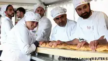 05.05.2024+++ French bakers stand near a large rotating oven in an attempt to beat the world record for the longest baguette during the Suresnes Baguette Show in Suresnes near Paris, France, May 5, 2024. REUTERS/Stephanie Lecocq 