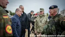 06.05.2024+++ Pabrade - Bundeskanzler Olaf Scholz (2.v.l, SPD) wird vom litauischen Staatspräsidenten Gitanas Naueda (3.v.l) und Soldaten bei dem Besuch der Nato-Übung Quadriga 24 begrüßt.