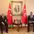 MHP Genel Başkanı Devlet Bahçeli ve CHP lider Özgür Özel, arkada Atatürk fotoğrafı ile Türk ve MHP bayrakları görülüyor