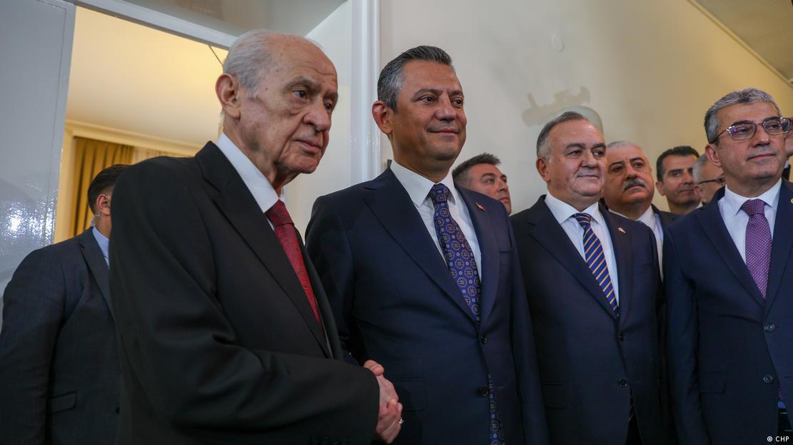 MHP lideri Bahçeli ile Özel el sıkışıyor, 2024 yılındaki bu ziyaret sırasında iki liderin yanlarında iki partiden siyasetçiler görülüyor