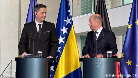 Dva muškarca za govornicom u pozadini BiH i EU zastave