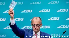 Friedrich Merz, CDU-Bundesvorsitzender, zeigt die Stimmkarte bei einem Änderungsantrag im Rahmen der Verabschiedung des neuen Grundsatzprogramms der Union. +++ dpa-Bildfunk +++