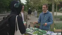 A German Green Party campaigner at his stall talks to locals