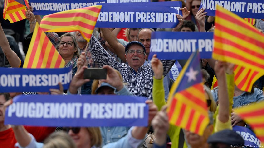 Seguidores del separatista Puigdemont en Cataluña ondean banderas catalanas y carteles que dicen: "Puigdemont president".