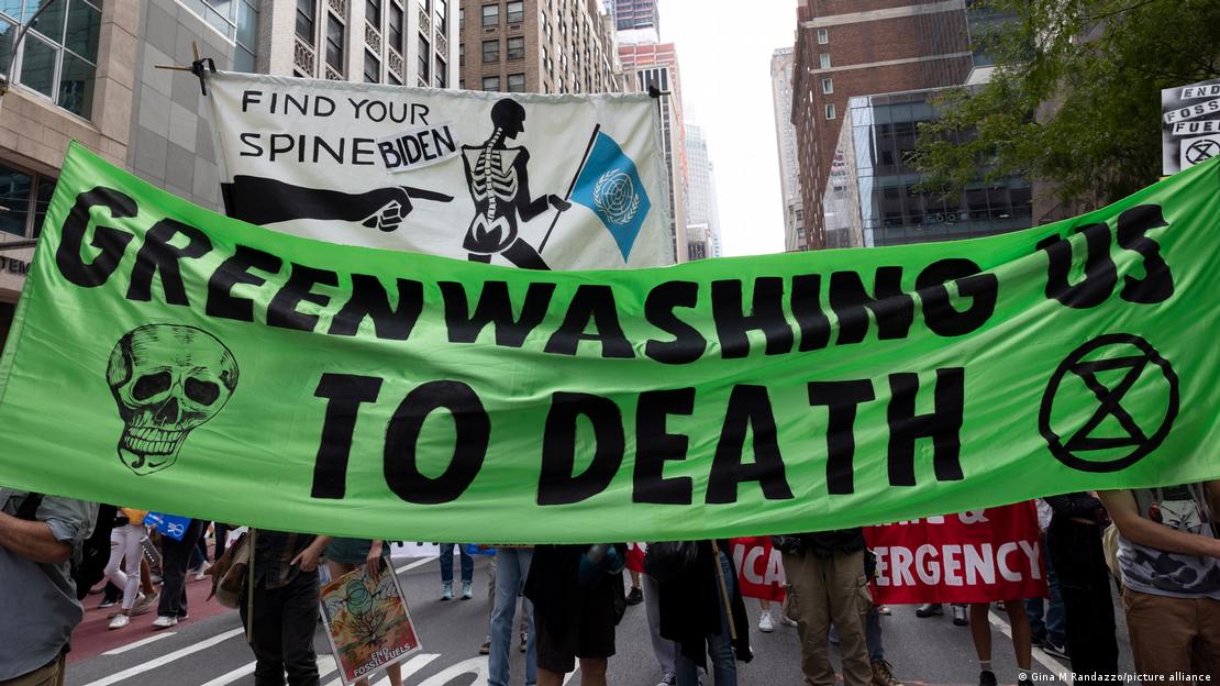Πανό ακτιβιστών που γράφει "Greenwashing us to death"