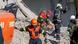Rescue workers and an excavator atop a pile of rubble in George, South Africa Rescue workers and an excavator atop a pile of rubble in George, South Africa