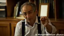 Zibakalam gestures with his left hand towards the camera during an interview in 2017