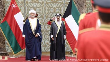 Sultan of Oman Haitham bin Tariq (Left) is welcomed by Emir of Kuwait, Mishal Al Ahmad Al Jaber Al Sabah with the countries' flags hanging in the background