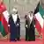Sultan of Oman Haitham bin Tariq (Left) is welcomed by Emir of Kuwait, Mishal Al Ahmad Al Jaber Al Sabah with the countries' flags hanging in the background