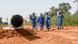 Bau der Öl-Pipeline zwischen Niger und Benin: Menschen in Arbeitskleidung am Rand der Baustelle Bau der Öl-Pipeline zwischen Niger und Benin: Menschen in Arbeitskleidung am Rand der Baustelle