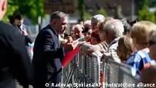 Slovakia's Prime Minister Robert Fico, centre, speaks with people before the cabinet's away-from-home session in the town of Handlova, Slovakia, Wednesday, May, 15, 2024. Prime Minister Robert Fico was shot and injured after the away-from-home government meeting in Handlova, according to information confirmed by Parliamentary Vice-Chair Lubos Blaha, who suspended the House session. (Radovan Stoklasa/TASR via AP)