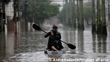 Residents row a boat in a flooded street after heavy rains, in Porto Alegre, Rio Grande do Sul state, Brazil, Saturday, May 11, 2024. (AP Photo/Andre Penner)