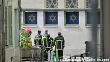 Fire brigade members stand by a synagogue in the Normandy city of Rouen where French police have killed earlier an armed man who was trying to set fire to the building on May 17, 2024. Two separate investigations have been opened, one into the fire at the synagogue and another into the circumstances of the death of the individual killed by the police, Rouen prosecutors said. The man threatened a police officer with a knife and the latter used his service weapon, he added. (Photo by LOU BENOIST / AFP) (Photo by LOU BENOIST/AFP via Getty Images)