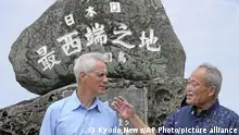 U.S. Ambassador to Japan Rahm Emanuel, left, and Yonaguni Mayor Kenichi Itokazu talk in front of a monument indicating Japan's westernmost point on Yonaguni Island in Okinawa prefecture, southern Japan Friday, May 17, 2024. Emanuel visited two southwestern Japanese islands at the forefront of tension with China's increasingly assertive actions in the regional waters. (Kyodo News via AP)