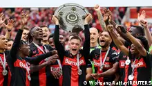 Soccer Football - Bundesliga - Bayer Leverkusen v FC Augsburg - BayArena, Leverkusen, Germany - May 18, 2024
Bayer Leverkusen's Florian Wirtz celebrates with the trophy and teammates after winning the Bundesliga and going unbeaten REUTERS/Wolfgang Rattay DFL REGULATIONS PROHIBIT ANY USE OF PHOTOGRAPHS AS IMAGE SEQUENCES AND/OR QUASI-VIDEO.