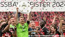 Bayer Leverkusen's Finnish goalkeeper #01 Lukas Hradecky and his teammates celebrate with the Bundesliga trophy after the German first division Bundesliga football match between Bayer 04 Leverkusen and FC Augsburg in Leverkusen, western Germany on May 18, 2024. (Photo by INA FASSBENDER / AFP) / DFL REGULATIONS PROHIBIT ANY USE OF PHOTOGRAPHS AS IMAGE SEQUENCES AND/OR QUASI-VIDEO ALTERNATIVE CROP (Photo by INA FASSBENDER/AFP via Getty Images)