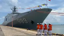 Chinese naval personnel line up in front of their warship dock at the port of Sihanoukville, Cambodia, Sunday, May 19, 2024. Two Chinese warships docked Sunday at a commercial port in Cambodia, in preparation for joint naval exercises between the two countries. (AP Photo)