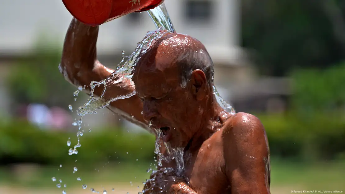 Un hombre se refresca echándose agua sobre la cabeza durante una ola de calor en Pakistán