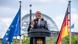 Frank-Walter Steinmeier speaks on a stage with the Reichstag behind him and flanked by Germany and EU flags Frank-Walter Steinmeier speaks on a stage with the Reichstag behind him and flanked by Germany and EU flags