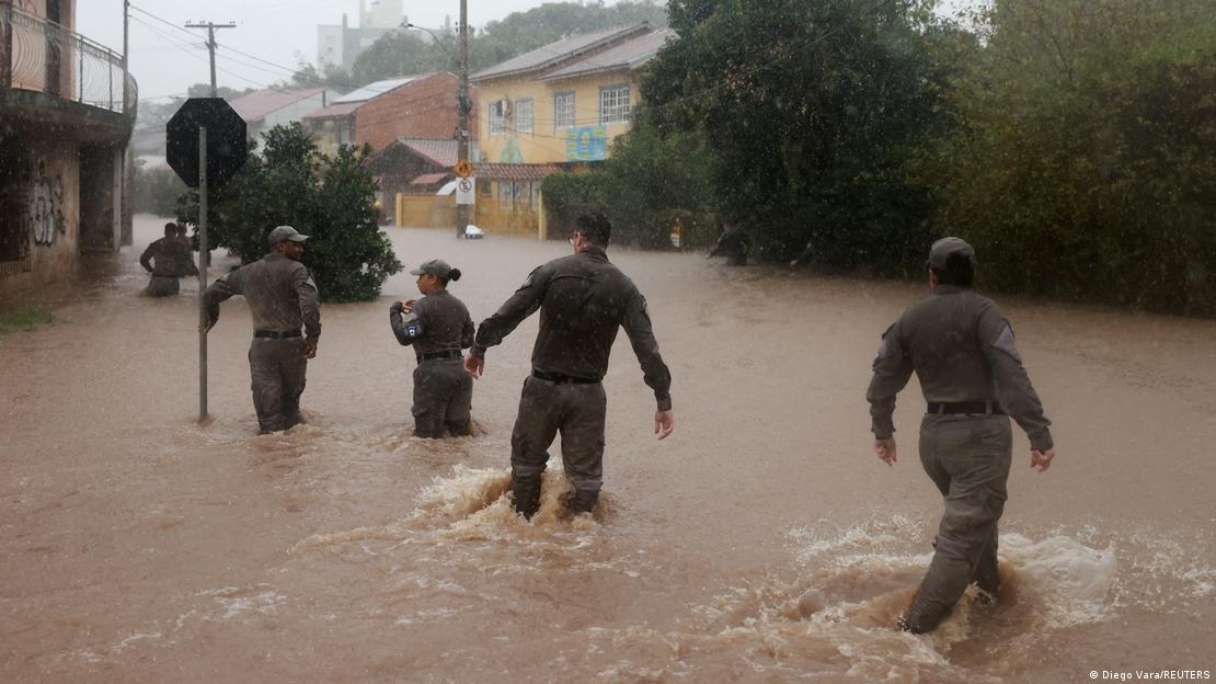 Efectivos de seguridad caminan por las calles inundadas en busca de víctimas.