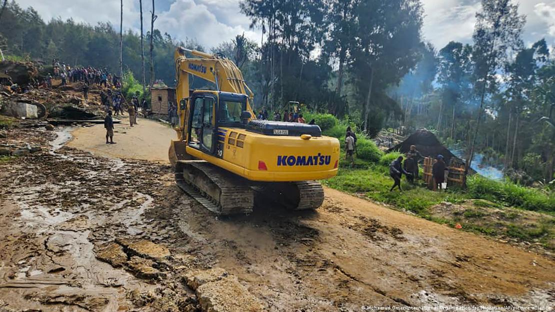 Villagers use heavy machinery to search through a landslide in Yambali in the highlands of Papua New Guinea