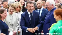 German President Frank-Walter Steinmeier with his wife Elke Budenbender and French President Emmanuel Macron with his wife Brigitte Macron react as they meet with people during the Democracy Festival to mark 75 years of the German Basic Law and 35 years of the peaceful revolution, in Berlin, Germany, May 26, 2024. REUTERS/Christian Mang