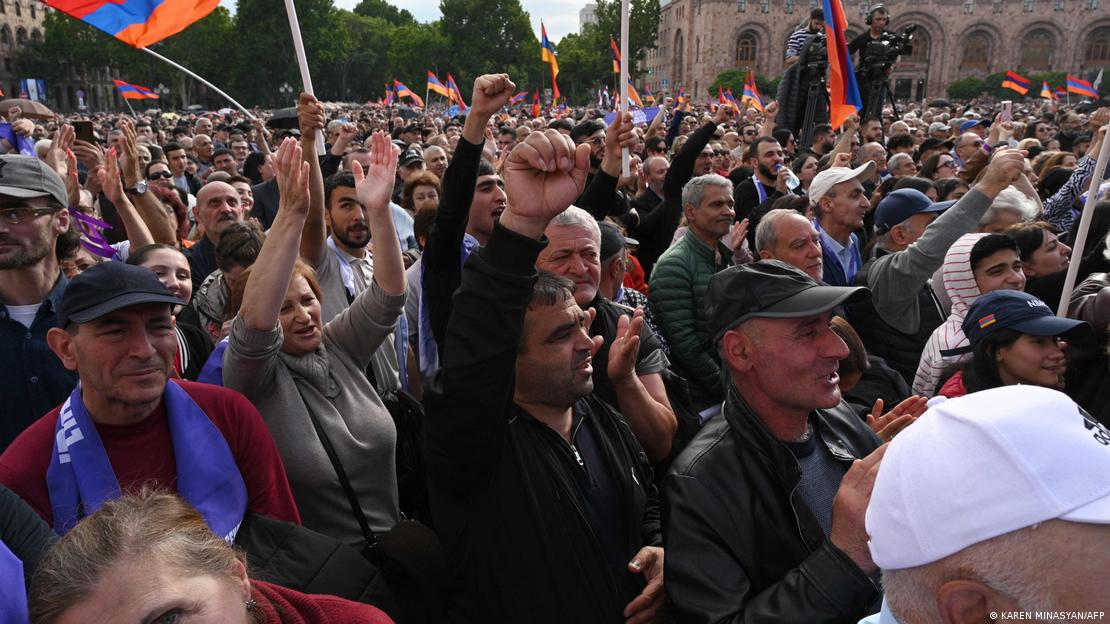 Protesters raise hands and clenched fists during the opposition rally in Yerevan