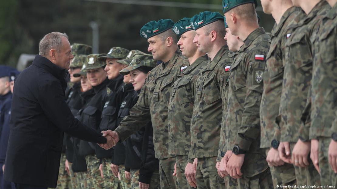 Donald Tusk shakes hands with soldiers, who are standing in a receiving line