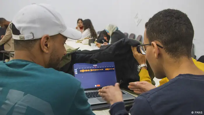 Journalists edit audio on a laptop using Colmena